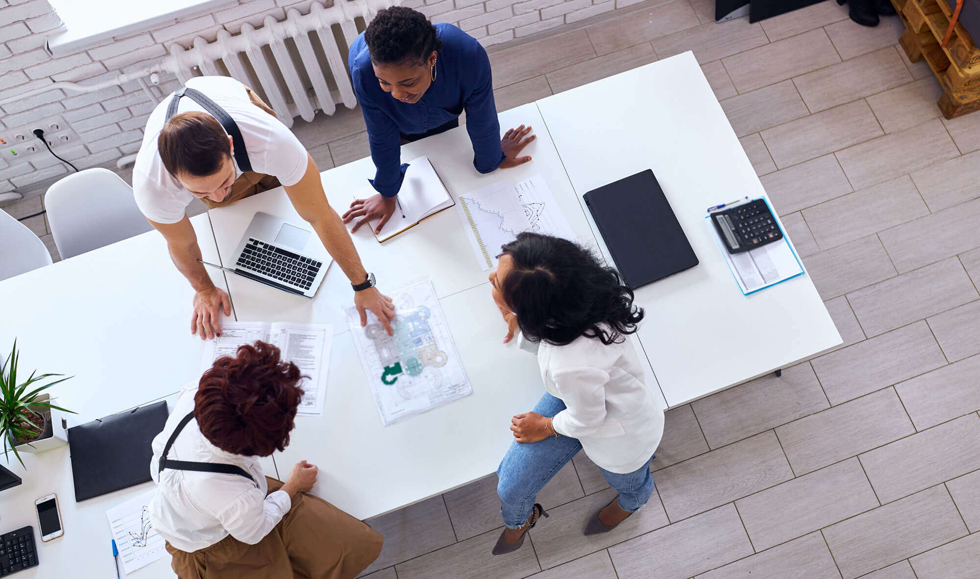 Overhead view of a business team consisting of multiethnic people gathered in a startup office to discuss new project.