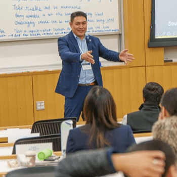 Photo of professor talking in front of the class.