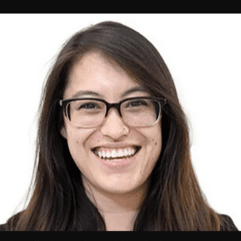 Brunette woman smiling with glasses.