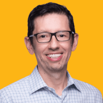 Photo of Fernando Lopez, MBA 06 –smiling, wearing button up shirt. Backdrop is Berkeley Gold color.