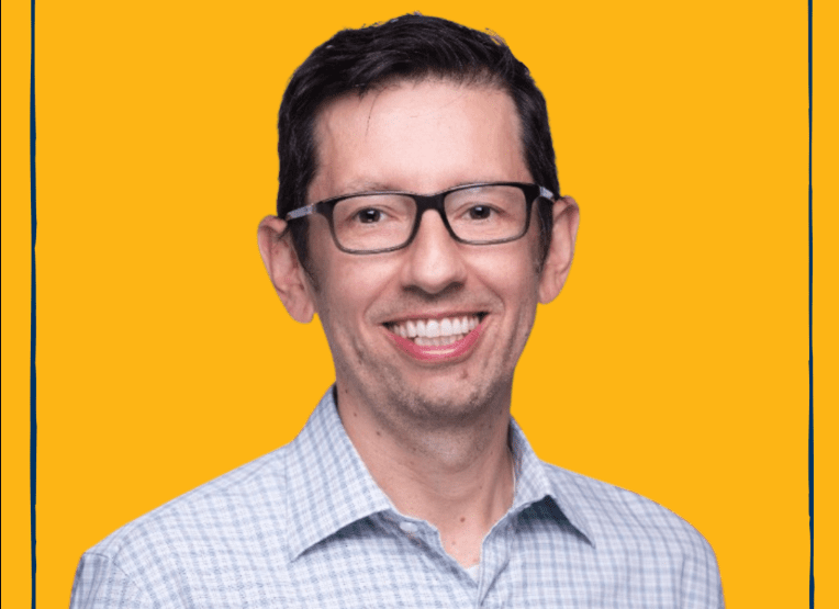 Photo of Fernando Lopez, MBA 06 –smiling, wearing button up shirt. Backdrop is Berkeley Gold color.