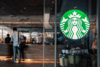 Photo of a Starbucks logo on an actual Starbucks glass window or door of storefront.