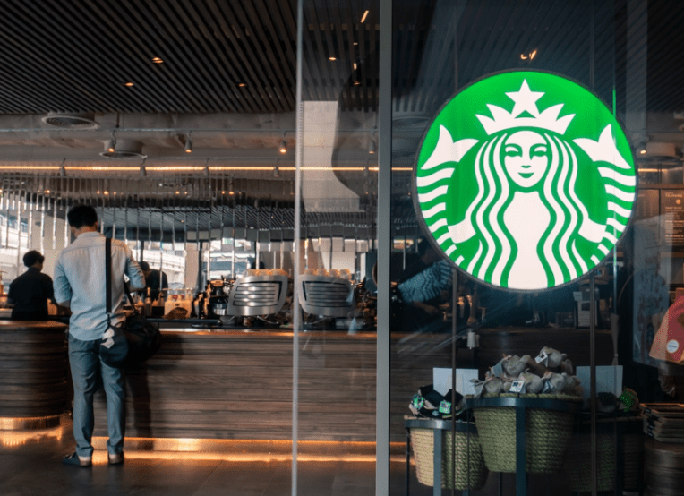 Photo of a Starbucks logo on an actual Starbucks glass window or door of storefront.