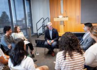 man sitting in a circle talking to students