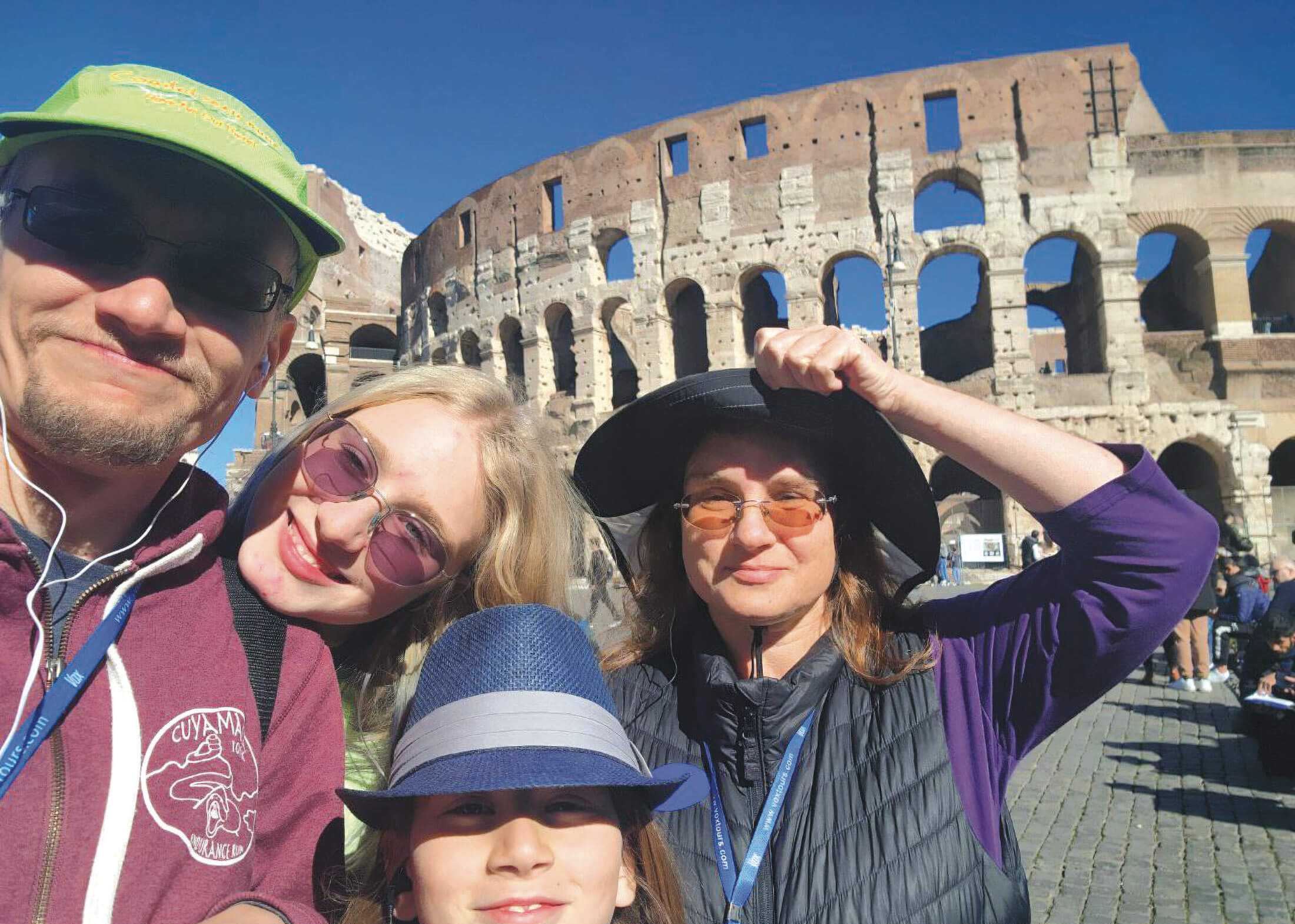 Two parents an two children stand in front of the Colosseum in Rome