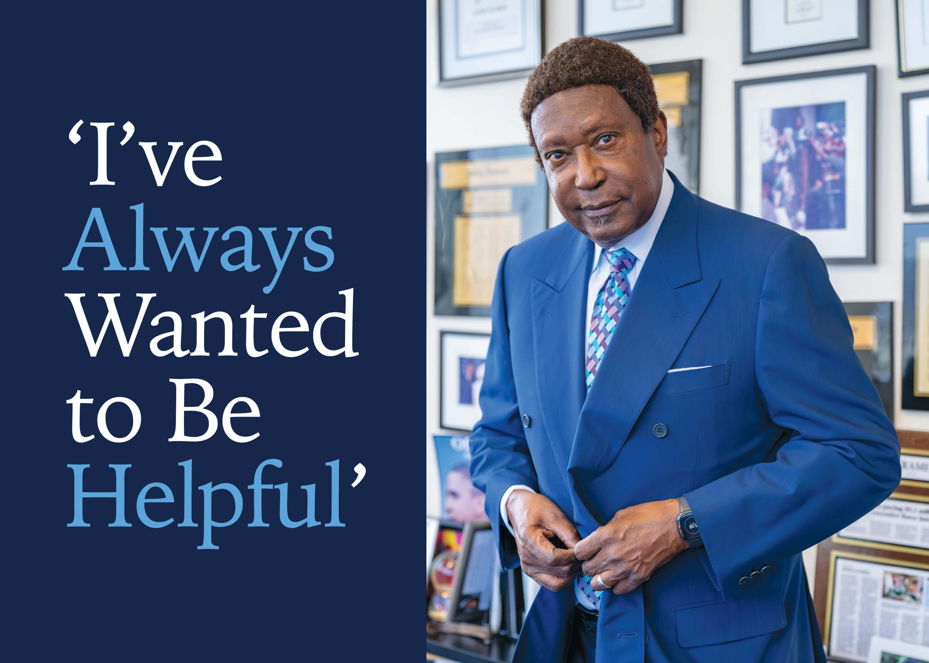 Person in a blue blazer in front of a wall of framed photos