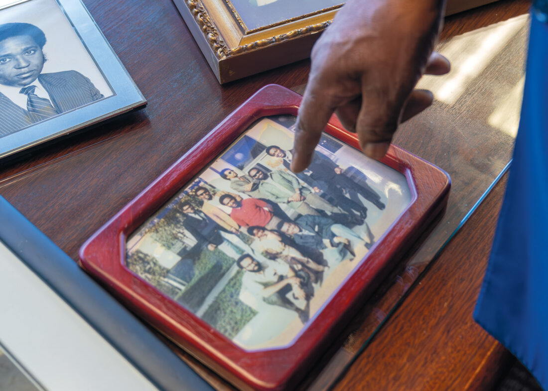 Hand points to a red framed photo on a table