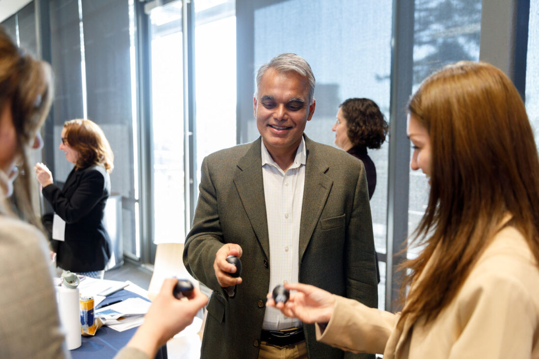 Two women and a man stand in a circle holding egg shakers and smiling.